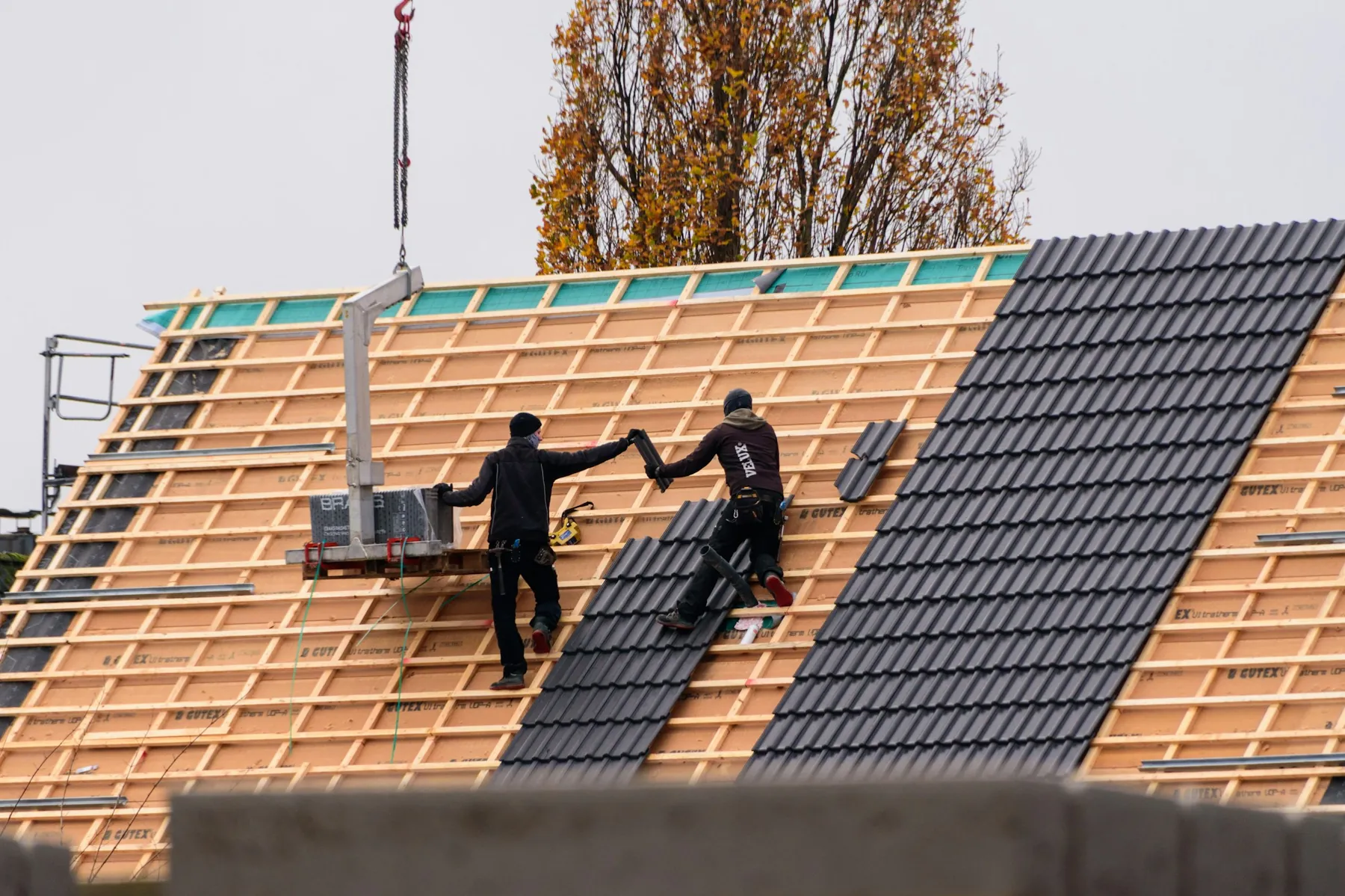 Roofing crew celebrating mid-install on a tile roof